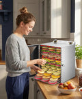 Woman using Powerful 800W Food Dehydrator Machine With 6, 8, 12 Or 18 Layer Stainless Steel Trays in kitchen