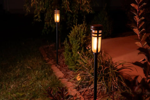 Metal Solar Torch Lights With Adjustable Height From 24 To 50 Inches For Outdoor Yard Patio And Garden Pathway Waterproof Tiki Torches In Matte Black Two Pack Featuring Patented LED Flame Effect And Realistic Flicker installed in garden pathway