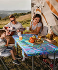 Family enjoying picnic with waterproof picnic table cover with bench covers for 6 foot rectangular tables, backdrop of an RV.