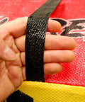Close up of hand holding handle of Yellow Jacket Supreme 3 Archery Target Bag Dual Sided 23 by 12 Inches Weatherproof 54 Layer Construction