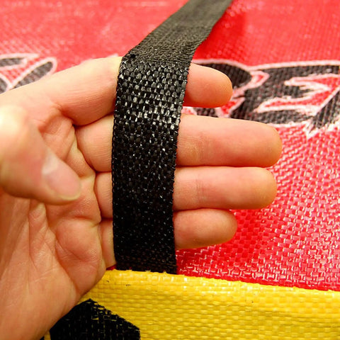Close up of hand holding handle of Yellow Jacket Supreme 3 Archery Target Bag Dual Sided 23 by 12 Inches Weatherproof 54 Layer Construction