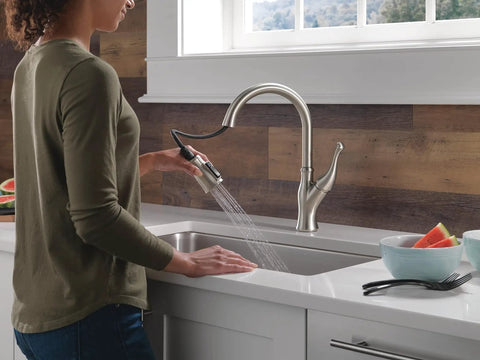 Modern Single Handle Kitchen Sink Faucet With Smooth As Silk Pull Down Sprayer In Grime Resistant Brushed Nickel featuring user operating sprayer.
