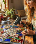 Person using Dual Watt Soldering Gun 400 And 150 Heavy Duty with Trig R Heat Control on stained glass project indoors.