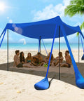 Beach scene with 10x10 Ft Beach Shade Canopy Tent With 8 Sandbags, UPF Fifty Plus Sun Shelter in blue, elevated for ventilation.