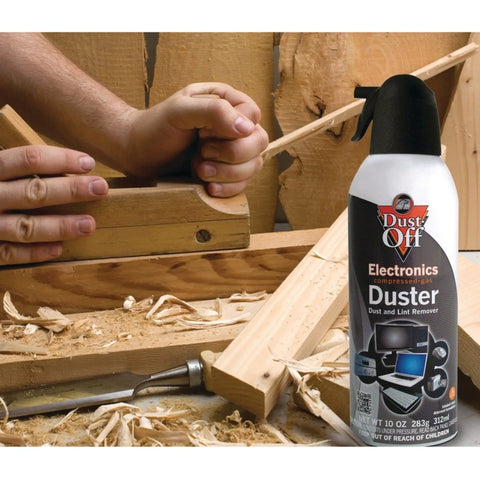 Two Pack 10 Oz Compressed Gas Dusters for quick cleaning of electronics like keyboards CPUs mice workstations next to wood shavings.