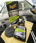 All In One Car Wax Cleaner That Cleans Dirt Grime And Water Spots, bottle and box on top of a polished black car hood, with pad and cloth