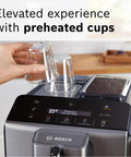 Fully Automatic Espresso Machine With Milk Frother System And Touch Control Panel Plus Cup Warmer For One Touch Latte And Cappuccino Maker In Sleek Dark Silver, showcasing preheated cups and touchscreen interface.