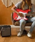 Person playing guitar with Frontman 10G 10 Watt Electric Guitar Amplifier With 6 Inch Speaker in a cozy room