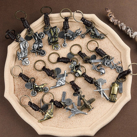 Assorted vintage leather and bronze bicycle keychains with metal wheels and handlebars on display