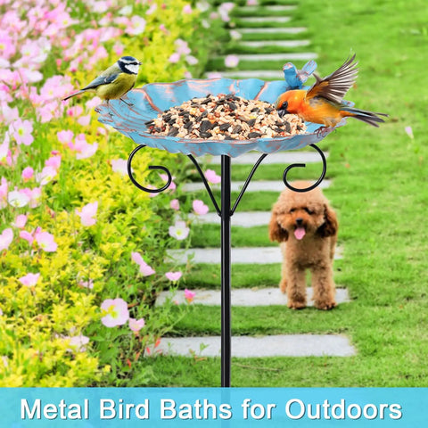 34 Inch Tall Metal Bird Bath On A Stake For Outdoors with birds feeding, set in a garden path with flowers and a dog in the background.