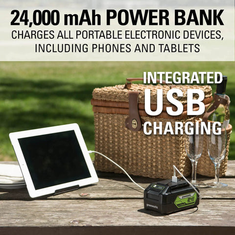 24,000 mAh power bank with integrated USB charging for phones and tablets on outdoor picnic table.