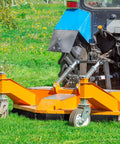 Tractor with orange mower attachment on grassy field for landscaping