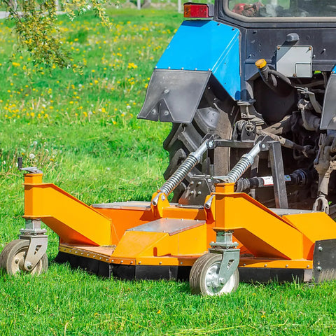 Tractor with orange mower attachment on grassy field for landscaping
