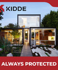 Modern glass house surrounded by trees with the Kidde logo and tagline 'Always Protected' at the top and bottom.