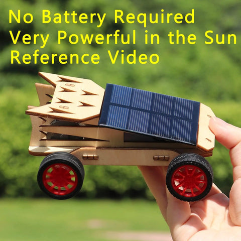 Hand holding solar car from Rockin Build It Solar Car and Remote Control Kit for Kids Aged 8-12 against outdoor background.