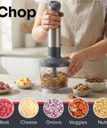 Person using Boss 5 In 1 Immersion Hand Blender Set With 800W Copper Motor And Titanium Reinforced Blades to chop nuts