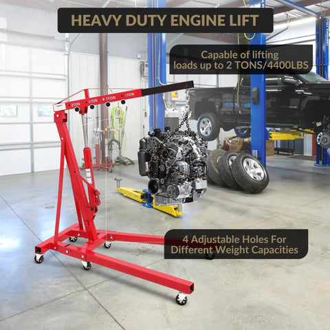 2 Ton Cherry Picker Engine Hoist Folds Flat To Save Bay Space Rolls Smooth On Six Heavy Duty Casters Includes Hand Pump For Garage Crew Auto Projects 4400 Lb, with engine hanging.