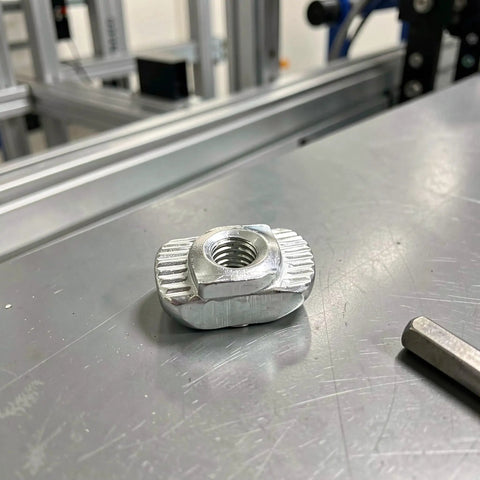 Hella Sturdy 150 Piece Sliding T Nut Set M3 Hammer Head T Slot Hardware Drop In Fasteners Fits 2020 And Eu 20 Aluminum Extrusion showing a silver t nut on a metal surface.