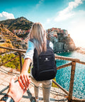 Traveler wearing a Lightweight Packable Travel Backpack 30L For Men And Women Black Foldable Daypack with scenic background