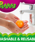 Person washing a Six Pack Tacky Fidget Ball under a faucet, showcasing safe reusable rubber material for sensory play.