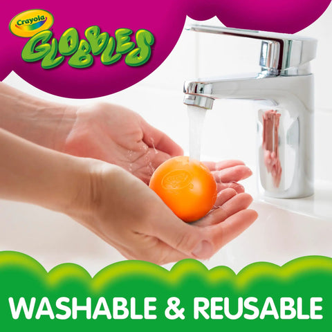 Person washing a Six Pack Tacky Fidget Ball under a faucet, showcasing safe reusable rubber material for sensory play.