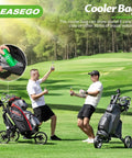 Two golfers enjoying drinks next to a three wheel golf push cart, featuring a cooler bag, smooth on the course.