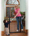 Adult and toddler interacting with Tall And Wide Auto Close Baby Gate With Magnetic Lock Technology, Pressure Mounted, in doorway