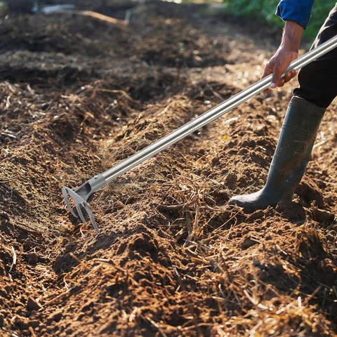 Person using Pro Grade Garden Hoe with 77 Inch Adjustable Handle for heavy duty weeding and cultivating in a garden.