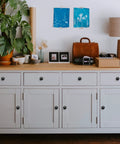 Matte Black Zinc Kitchen Cabinet Knobs And Drawer Pulls Set installed on white dresser drawers, 5/8 inch base, Euro style