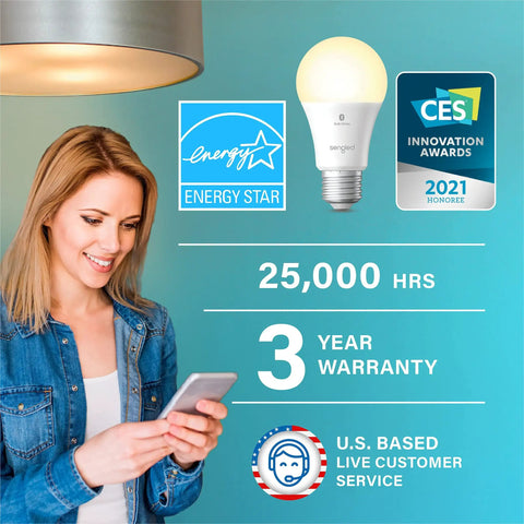 Woman using phone near Alexa Enabled Smart Light Bulbs Four Pack With Auto Pairing No App Or Hub Needed with awards shown.