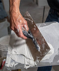 Flex Drywall Curved Trowel 12-Inch By 4.75-Inch With 0.5mm Blade spreading plaster on construction site