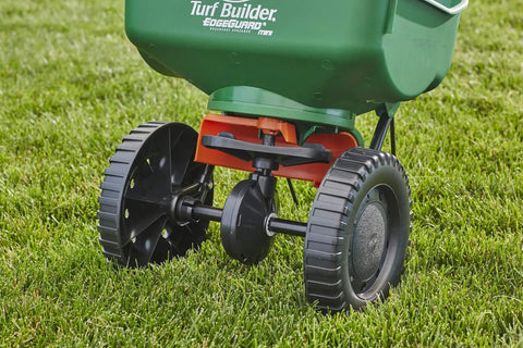 Edge Guard Mini Broadcast Spreader With Calibrated Settings And Wheels on grass, ideal for lawns up to 5,000 sq ft.