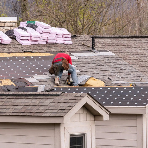 Worker installing roofing insulation using Premium Grade 3 Inch Roofing Insulation Barbed Plates Galvanized Metal Fasteners.