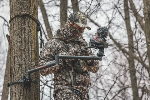 Hunter using Stiff Arm Tree Camera Arm Mount, Lightweight Aluminum With 360 Tool-Less Leveling in a forest