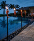 55 Inch Outdoor Oil Torch Lamps 2 Pack In Rose Gold, Rustproof Stainless Steel Citronella Torches by poolside at dusk