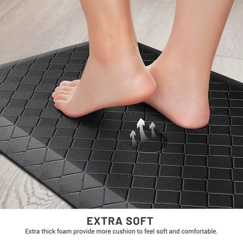 Foot resting on black Ergonomic Anti Fatigue Kitchen Floor Mat 4 To 5 Inch Thick Waterproof Non Slip Rug for standing comfort.