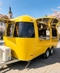 Top Tier Stainless Steel Food Trailer A Solid 16 Foot Yellow Mobile Kitchen Built Tough And Dot Certified For Street Ready Operators Running A Smooth Hustle With Zero Headache Logistics, exterior view with opened serving windows.
