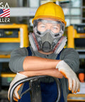 Worker wearing yellow hard hat and respirator mask with 8-Pack Replacement Carbon Filters For Respirator Masks in workshop.