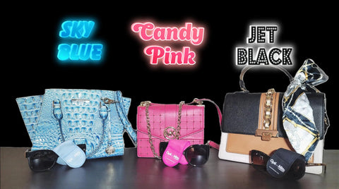 Group of handbags and sunglasses on a surface with neon signs reading Sky Blue, Candy Pink, Jet Black.