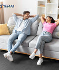 Two people relaxing on a sofa with grey EVA Interlocking Floor Mats With Puzzle Tiles 12x12 Inch Foam Padding Border for flooring.