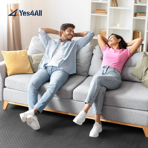 Two people relaxing on a sofa with grey EVA Interlocking Floor Mats With Puzzle Tiles 12x12 Inch Foam Padding Border for flooring.