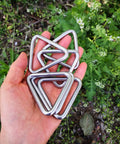 Hand holding Stainless Steel 316 Marine Grade Triangle Ring Buckle Welded V Shaped Heavy Duty Ring Set Of Six One Quarter Inch By Two Inch