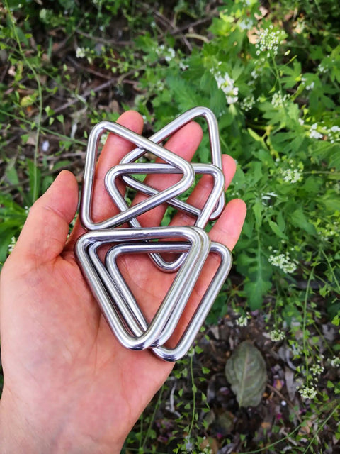 Hand holding Stainless Steel 316 Marine Grade Triangle Ring Buckle Welded V Shaped Heavy Duty Ring Set Of Six One Quarter Inch By Two Inch