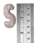 Pink packing peanuts for shipping and moving, showing a piece beside a ruler for size comparison.