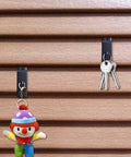 Metal Slatwall Utility Hooks 10 Pack Set Heavy Duty Slatwall Hangers For Photos Frames Paintings And Art Displays Black Galvanized Finish Notch Design For Secure Mount Durable And Corrosion Resistant Easy Install holding keys and a toy clown