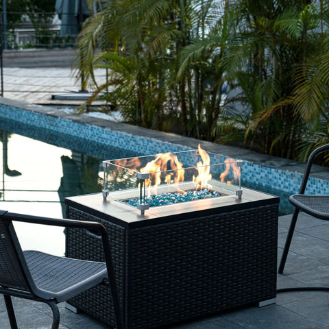 Poolside gas fire pit with Caribbean Blue 20 Pound 1 Inch Fire Glass Diamonds For Gas Fire Pit And Fireplace, flames glowing.