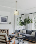 Cozy Linen Shade Pendant Light With Cream White Shade In Gold Cage, Adjustable Cord And Canopy, ETL Listed in a living room.