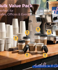 Assorted sizes of disposable coffee cups with lids on a counter near a coffee machine.