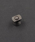 Black M-LOK M5 screw and T-nut hardware component on dark textured surface, front view