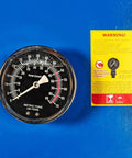 Close-up of pressure gauge on 50-Ton Hydraulic Shop Press With Floor Mount, Air Operated Foot Pedal Or Manual Operation next to warning label.